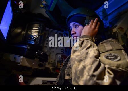 Army Sgt. Mayra Haynes, nativo di Anaheim, California, assegnato alla 95th Chemical Company, "Arctic draghi" XVII contro il supporto del battaglione di supporto, U.S. Esercito di Alaska, riceve gli ordini dal suo leader di squadra prima di impegnare un bersaglio durante un gunnery live-fire esercizio con M1135 Stryker nucleare Chimica Biologica Veicoli di ricognizione su base comune Elmendorf-Richardson, Alaska, Aprile 5, 2017. Il gunnery testato soldato proficiency con identificazione, di impegno, ed eliminando bersagli ostili pur aumentando efficacia in combattimento. Il Styker NBCRV fornisce nucleari, biologiche e chimiche Foto Stock
