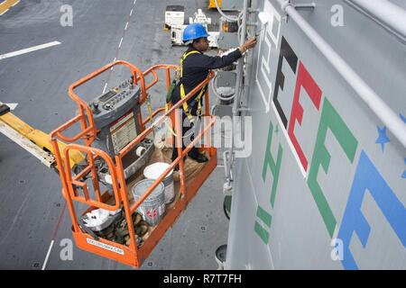 Spiaggia Bianca, Okinawa (Aprile 6, 2017) Quartermaster marinaio Daija Anderson, da Houston, dipinge una "E" sulla sovrastruttura dell'assalto anfibio nave USS Bonhomme Richard (LHD 6) per indicare il comando's 2017 Battaglia efficacia Award (Battaglia "E"). La superficie navale il comando delle forze (COMSURFOR) battaglia "E" il premio viene assegnato ogni anno ai migliori navi nell'Atlantico e nel Pacifico flotte e che riconosce un comando prolungato di prestazioni superiori. Bonhomme Richard, ammiraglia del Bonhomme Richard anfibio gruppo pronto, è su una pattuglia, operando in Indo-Asia-regione del Pacifico per migliorare warfight Foto Stock