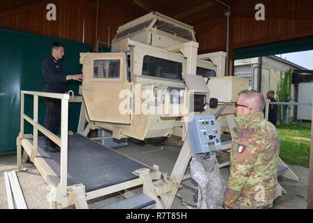 Carabinieri del 7° Reggimento Carabinieri "Laives" Bolzano e xiii reggimento Carabinieri "Friuli Venezia Giulia Gorizia condurre attività di formazione utilizzando la elevata mobilità multiuso di veicolo su ruote (HMMWV) assistenza egress trainer (calore), a Caserma Ederle Vicenza, Italia, Aprile 6, 2017. Il simulatore consente ai soldati di pratica uscire dai veicoli, di competenze e di impegnarsi in scenari realistici. Uso dei Carabinieri U.S. RTSD esercito sud attrezzatura per migliorare le relazioni bilaterali e per espandere i livelli di cooperazione e la capacità del personale coinvolto nelle operazioni congiunte. Foto Stock