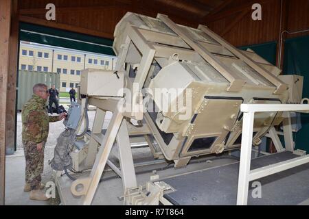 Sgt. Il Mag. Massimo Giordano esercito italiano, assistono i Carabinieri del 7° Reggimento Carabinieri "Laives" Bolzano e xiii reggimento Carabinieri "Friuli Venezia Giulia Gorizia, durante il training con la elevata mobilità multiuso di veicolo su ruote (HMMWV) assistenza egress trainer (calore), a Caserma Ederle, Aprile 6, 2017, Vicenza, Italia. Il simulatore consente ai soldati di pratica uscire dai veicoli, di competenze e di impegnarsi in scenari realistici. Uso dei Carabinieri U.S. RTSD esercito sud attrezzatura per migliorare le relazioni bilaterali e per espandere i livelli di cooperazione e la capacità del personale Foto Stock