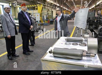 Arsenal macchinista supervisore Terry Van Vranken, a destra per spiegare un processo di rigatura per obice tubi per American Legion National Vice comandante Vincent J. Troiola, centro con cappuccio rosso, Troiola durante la visita all'Arsenal il 6 aprile 2017. Foto Stock