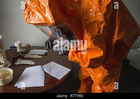 Il personale Sgt. Nicky Lam con il New Jersey Guardia Nazionale della ventunesima armi di distruzione di massa supporto Destruction-Civil Team, fotografie prove reperite presso un laboratorio simulato sito durante una formazione congiunta di esercitare con membri del Monmouth County Hazmat Team a Fort Monmouth, N.J., Aprile 6, 2017. Il ventunesimo WMD-CST è una unità di snodo compreso del New Jersey e la Guardia Nazionale di soldati e aviatori la cui missione è quella di sostenere le autorità civili identificando chimici, biologici, radiologici e nucleari in sostanze artificiali o calamità naturali. (New Jersey Guardia Nazionale Foto Stock