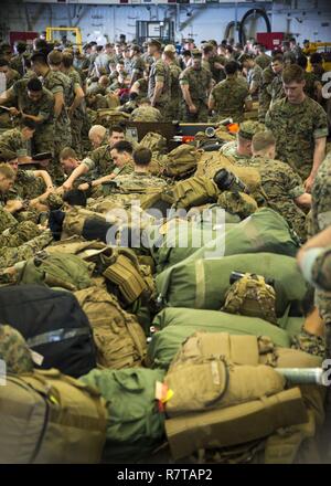 Spiaggia Bianca, Okinawa (Aprile 6, 2017) Marines, assegnato al trentunesimo Marine Expeditionary Unit, assemblare in hangar bay prima di un personale sbarcherete dall'assalto anfibio nave USS Bonhomme Richard (LHD 6). Bonhomme Richard, ammiraglia del Bonhomme Richard anfibio gruppo pronto è su una pattuglia, operando in Indo-Asia-regione del Pacifico per migliorare la prontezza combattimento e la postura in avanti come una pronta risposta in vigore per qualsiasi tipo di emergenza. Foto Stock