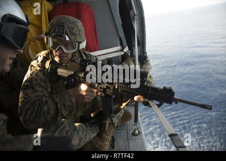 Il Mag. Issac Moore, delegato per il battaglione Team di atterraggio, 2° Battaglione, 5 Marines, l uomo un M27 Fanteria Fucile automatico da parte del personale Sgt. Matt Tippett, un capo scout sniper plotone, BLT 2/5, 31 Marine Expeditionary Unit, in un MH-60S Sea Hawk, sull'Oceano Pacifico, 28 marzo 2017. La Scout Sniper condotte aeree formazione cecchino come parte del trentunesimo MEU's 17.1 pattuglia di primavera. Come il Marine Corps' solo in continuo in avanti dispiegato unità, il trentunesimo MEU's aria-terra-team Logistics fornisce una forza flessibile, pronto per eseguire una vasta gamma di operazioni militari, dalla contingenza limitata a umano Foto Stock