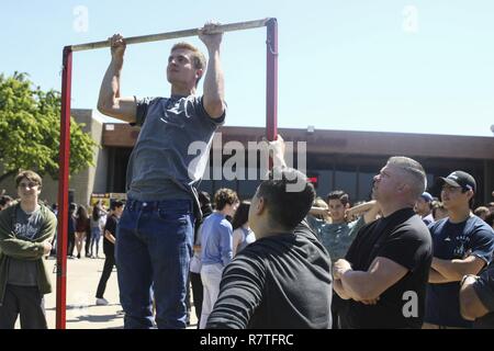 Sgt. Eric Moroney e il suo futuro Marines monitorare il pull-up challenge a Torrey Pines High School, San Diego, California, 5 aprile 2017, durante l'ASA Entertainment anti-bullismo tour. ASA personale di animazione, BMX pro rider e Marine Corps reclutatori viaggiato di più scuole, aprile 3-7, 2017, per la diffusione di anti-bullismo consapevolezza e insegnare agli studenti come affrontare il bullismo. Moroney, da Boston, Massachusetts è un selezionatore con Marine Corps Recruiting Station San Diego, XII Marine Corps il reclutamento di distretto, Occidentale Regione di reclutamento, Marine Corps il reclutamento di comando. Foto Stock