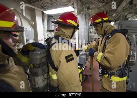 Oceano Pacifico (8 aprile 2017) dello scafo tecnico di manutenzione di terza classe Leroy Malone, Phoenix nativi e dà istruzioni al suo team a bordo Arleigh Burke-class guidato-missile destroyer USS Sterett (DDG 104) durante uno spazio principale drill incendio. Sterett è parte della superficie Sterett-Dewey Action Group ed è il terzo gruppo di distribuzione che operano sotto il comando ed il controllo costrutto denominato 3a flotta in avanti. Stati Uniti 3a flotta operante in avanti offre opzioni aggiuntive per la flotta del Pacifico commander sfruttando le capacità del 3° e 7° flotte. Foto Stock