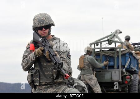 Stati Uniti La riserva di esercito di Spc. Jeremy Haines con la mobilità 979th Augmentation Company, ingegnere 478th battaglione, ingegnere 926th brigata, 412 Teatro comando ingegnere, basato in Lexington, KY., fornisce 'security' Come Sgt. Cederic scudiero prepara una mia linea di cancellazione addebito per la detonazione durante la formazione della società a Wilcox gamma su Fort Knox, Ky., 1 aprile 2017. Ciò era parte della qualifica Tecnico tabella XII. Questa società è stata la prima U.S. Esercito di unità di riserva per realizzare questo feat. Foto Stock