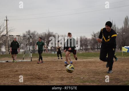 Un Arizona soldato della protezione nazionale le gare per la palla durante una partita di calcio contro i soldati del Regno Unito con il primo battaglione, fucili, 160 brigata, Aprile 2, 2017, a Illisky Training Center, il Kazakistan. I soldati stanno partecipando a steppa Koktem Eagle, la fase uno della steppa multinazionale Eagle esercizio. Foto Stock