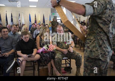 Stati Uniti Marine Corps Master Sgt. Daniel Tremore, unità di fanteria leader, 1° Divisione Marine, presenta Master Gunnery Sgt. Bruce Knapp, operazioni chief, 1° Divisione Marine, con un dono durante la sua cerimonia di pensionamento, a Camp Pendleton, California, 7 aprile 2017. Knapp reitred dopo aver servito per 29 anni in Marine Corps. Foto Stock