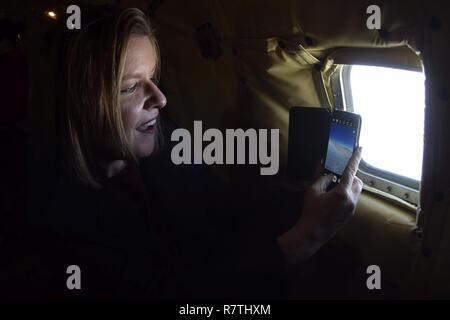 Debra Toufel, Università di Oklahoma Prezzo College of Business Director di partenariati pubblico-privato e membro della Tinker Air Force Base comandante onorario della classe 2017 prende una foto attraverso la finestra di fusoliera di un KC-135R Stratotanker durante una formazione locale volo Aprile 6, 2017 da Tinker Air Force Base in Oklahoma. Il comandante onorario è imparato circa la missione della 507th Air Refuelling Wing, Air Force comando Reserve, durante un rifornimento di aria la missione con F-16 Fighting falchi della 138th Fighter Wing, Oklahoma Air National Guard. Foto Stock