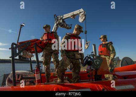 Un equipaggio di U.S. La riserva di esercito di soldati dal 949th Transportation Company, una unità che è specializzata in operazioni di natante, cargo e ingegneria del natante, posano con una gru idraulica e di un battello per una serie di ritratti e immagini raffiguranti la loro occupazione militare specialità di bordo di un supporto logistico in nave Baltimore, Md., su aprile 7-8, 2017. I soldati sono Spc. Dylan Nizza, SPC. Huy Dinh e SPC. Angelina Utanes. Foto Stock