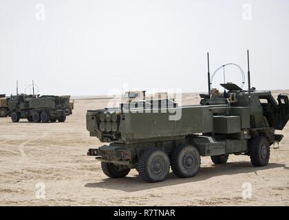 Due High Mobility Artillery Rocket System sistemi di armamenti (verdi), con 3 ° Battaglione, campo 157reggimento di artiglieria, attendere al punto di osservazione 10 durante un live-fire tabella VI gunnery, 29 marzo Udairi gamma complessa, Kuwait. Lo scopo del live-fire gunnery è di convalidare e qualificare le tre squadre di uomo necessaria per azionare un HIMARS. Foto Stock