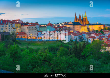 Praga Hradcany, inizio sera vista da sopra il parco Petrin treeline verso il Hradcany quartiere del Castello di Praga, Repubblica Ceca. Foto Stock