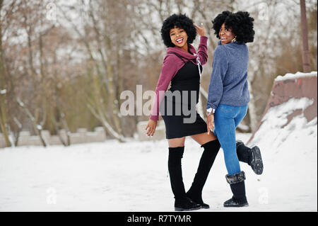 Due capelli ricci americano africano donna usura maglioni poste al giorno d'inverno. Foto Stock