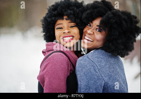 Due capelli ricci americano africano donna usura maglioni poste al giorno d'inverno. Foto Stock