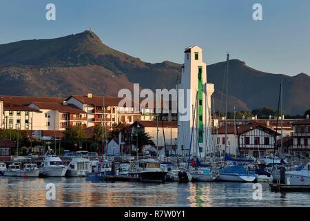 Francia, Pirenei Atlantiques, Paese Basco, Saint Jean de Luz, la barca al porto e il faro di Ciboure costruito da André Pavlovsky nel 1936, il vertice di Larrun (La Rhune) mountain in background Foto Stock