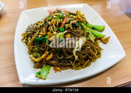 Fritto cinese spaghetti di vetro su una piastra con verdure e carne Foto Stock