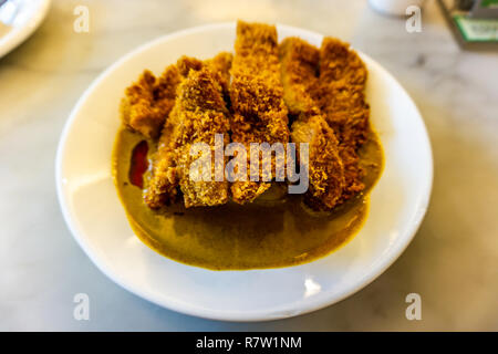 Fritti di Hong Kong costoletta di maiale con curry su una piastra Foto Stock