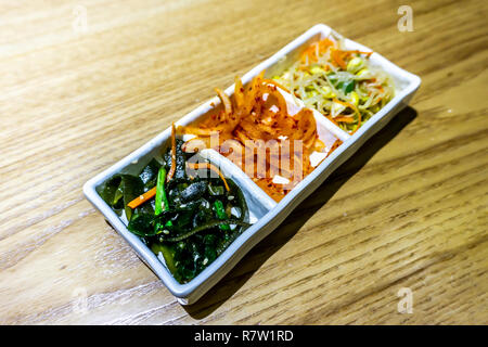 Coreano piatti laterali con i germogli di soia stagionata Alghe e fette di ravanello Foto Stock