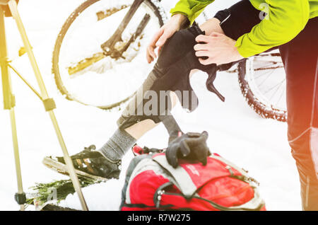 L'uomo rider mette su shin e la protezione delle ginocchia prima del training. Sport corpo il concetto di protezione Foto Stock