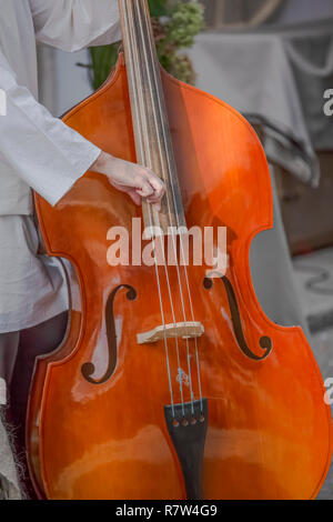 Vista della persona che gioca double bass sulla strada... Foto Stock