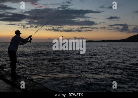 Napo'opo'o, Hawaii - un uomo pesci dopo il tramonto nella Baia di Kealakekua su la Big Island delle Hawaii. Foto Stock