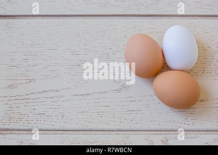 Ingredienti per la cottura di uova, e utensili per la cucina su un tavolo di legno, vista dall'alto. Foto Stock