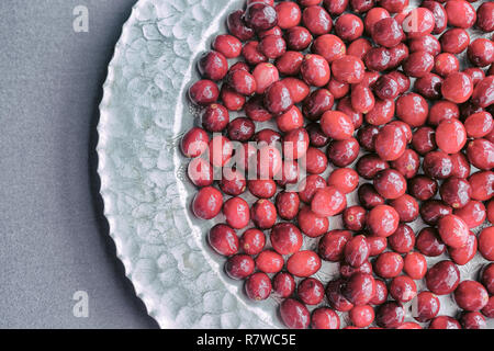 Cranberries su un antico piatto d'argento. Foto Stock