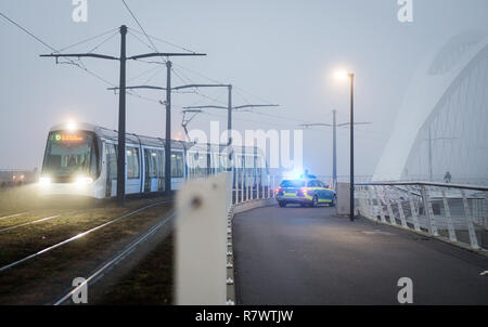 Kehl, Germania. 12 Dic, 2018. La fermata del tram tra Kehl e Strasburgo si attraversa un ponte sul confine franco-tedesco a Kehl, mentre gli ufficiali di polizia verificare i pedoni e i ciclisti. Secondo il governo francese, tre persone sono state uccise e dodici feriti in un attentato a Strasburgo il Martedì sera. La polizia assumono un sfondo terroristico. Credito: Christoph Schmidt/dpa/Alamy Live News Foto Stock