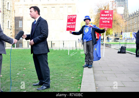 Londra, Regno Unito. 12 dic 2018. I politici e i media di tutto il mondo si riuniscono su College Green, Westminster, prima del voto di fiducia più tardi in Parlamento su Theresa Maggio la leadership del partito conservatore. Intervista photobombed da Steve Bray Credito: PjrFoto/Alamy Live News Foto Stock