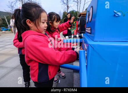 Changxing cinese della provincia dello Zhejiang. 12 Dic, 2018. I bambini di un Asilo locale prendere parte a una cernita dei rifiuti gioco durante una coscienza ambientale attività Qingcaowu nel villaggio di Lijiaxiang township di Changxing County, Huzhou, est della Cina di Provincia dello Zhejiang, Dic 12, 2018. Credito: Xu Yu/Xinhua/Alamy Live News Foto Stock