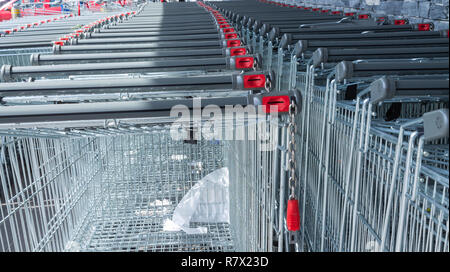 Carrelli della spesa a gettone impilati al di fuori di un supermercato o la vendita al dettaglio di prodotti alimentari in uscita. Foto Stock
