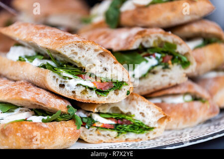 Vista dettagliata del display fresco di una pila di pila di panini pane, mozzarella formaggio fuso, vegetariana pomodoro italiano, basilico lattuga in negozio, negozio cafe bu Foto Stock