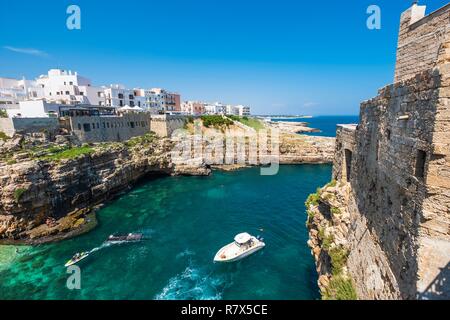 L'Italia, Puglia, Polignano a Mare, il centro storico è arroccato su una rupe calcarea che si affaccia sul Mare Adriatico, vista del lungomare Domenico Modugno Foto Stock