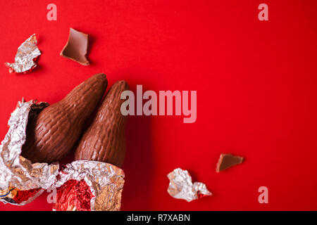 Natale dolci tradizionali su sfondo rosso. Il cioccolato Santa clausole avvolto in carta stagnola. Spazio di copia Foto Stock