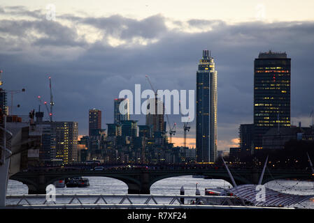 Lo skyline di Londra al tramonto con luci per gli edifici di sera. Il fiume Tamigi. Costruzione di gru. Westminster Bridge. Nine Elms. Edificio. Persone Foto Stock