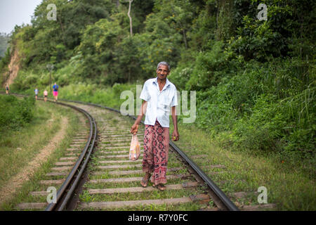 Ella, Sri Lanka - 5 Agosto 2018: un locale uomo a camminare sui binari del treno Foto Stock