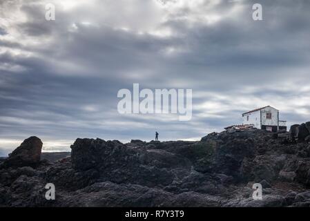 Portogallo Azzorre, isola Pico, Lajido, solitaria figura nel paesaggio vulcanico Foto Stock