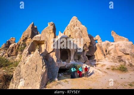 Turchia, Anatolia centrale, Nev&#x15f;ehir provincia, Cappadocia UNESCO World Heritage Site, Göreme, una famiglia turco scopre il paesaggio iconica del tufo vulcanico delle colline e dei resti di abitazioni troglodite nel Parco nazionale di Göreme Foto Stock