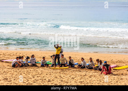 Manly, Australia - 12 Giugno 2015: i giovani che frequentano una scuola di surf sulla spiaggia. La navigazione è una delle attività più popolari. Foto Stock