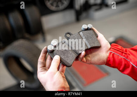 Meccanico Auto azienda nuova pastiglia del freno all'auto di servizio, vista da vicino Foto Stock