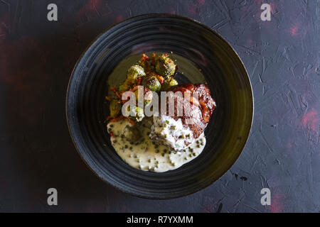 Bistecca di manzo fritto con cavolini di Bruxelles e cremosa salsa di piselli Foto Stock