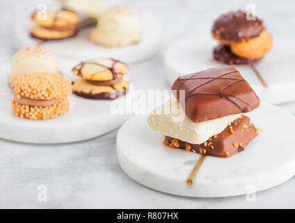 Il lusso di cioccolato belga e biscuit Cookie selezione sulle montagne russe in marmo e tavolo da cucina dello sfondo. Foto Stock