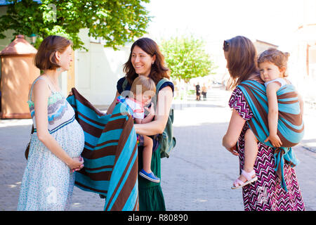 Due madri di dare consigli a loro amico in stato di gravidanza Foto Stock