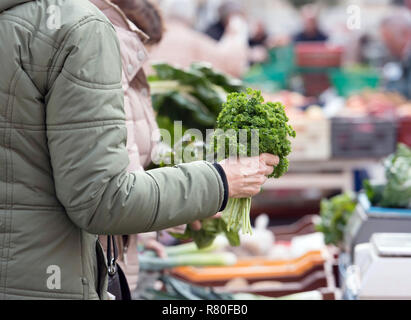 Privas (sud-est della Francia): mercato del sabato mattina. Mano di un cliente, donna, tenendo un mazzetto di prezzemolo. Foto Stock