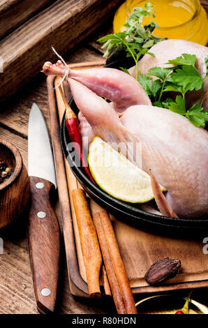 Crudo fresco quaglia su una scheda di cucina e gli ingredienti Foto Stock