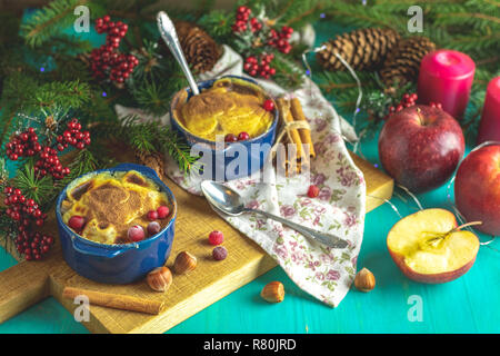 Natale e Anno Nuovo composizione con dolce di mele deliziosi dessert, rami di abete rosso, posate su blu turchese tavolo in legno superficie, copia spice, H Foto Stock