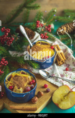 Natale e Anno Nuovo composizione con dolce di mele deliziosi dessert, rami di abete rosso, posate su blu turchese tavolo in legno superficie, copia spice, H Foto Stock