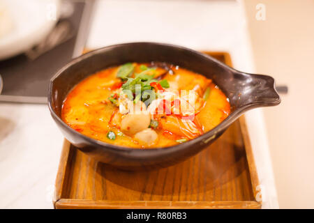 Tom Yum Goong (Tom Yum Kung), tailandese tradizionale amaro e piccante Tiger zuppa di gamberi sul vassoio in legno, cucina a base di pesce o di gamberetti piatto Gamberi comunemente servito come Foto Stock