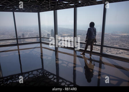 Una donna turistica indiana pubblica foto sulla piattaforma di osservazione del Burj Khalifa a Dubai, Emirati Arabi Uniti. Foto Stock